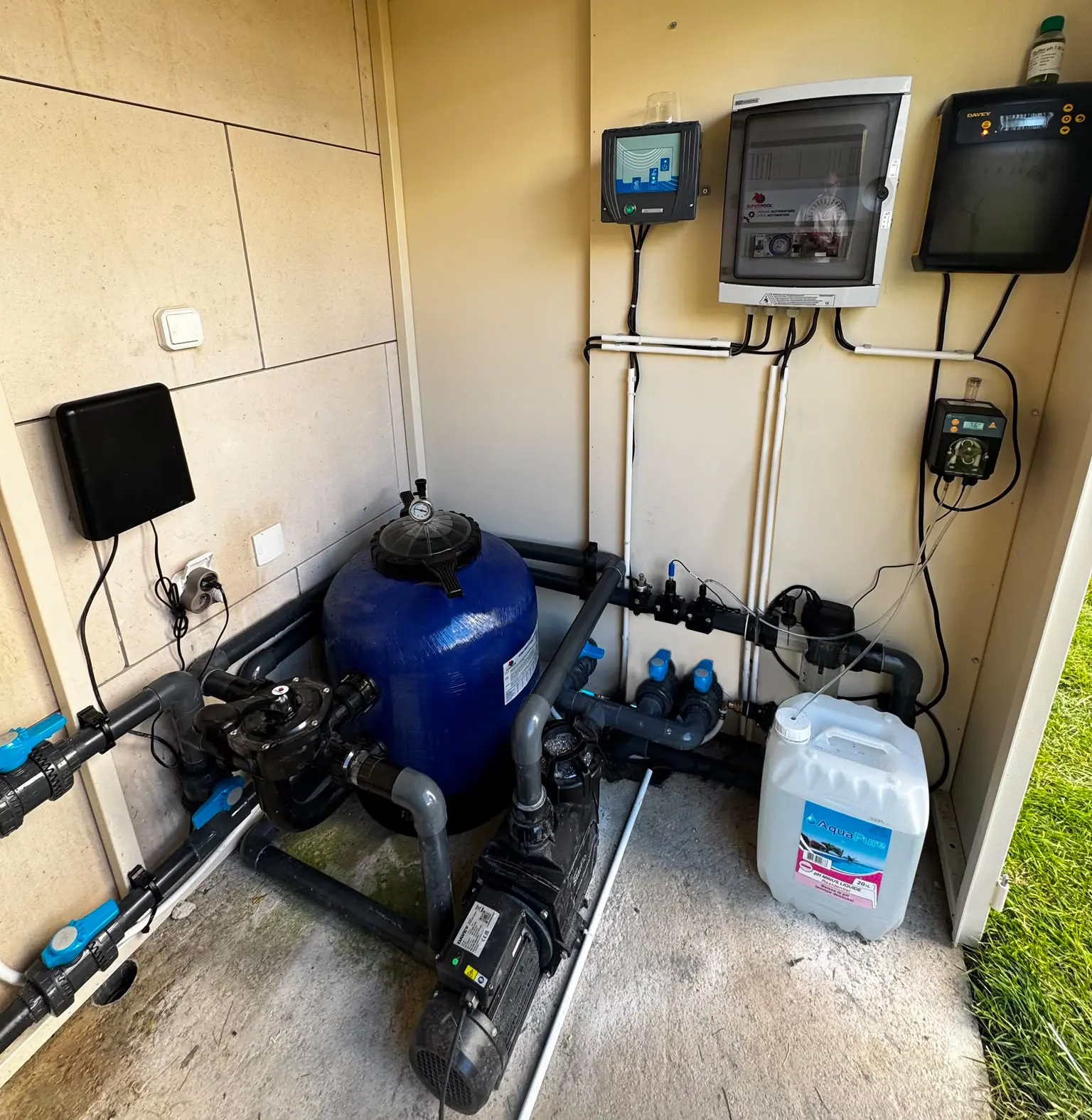 Local technique de traitement et filtration piscine avec réservoir bleu et pompes