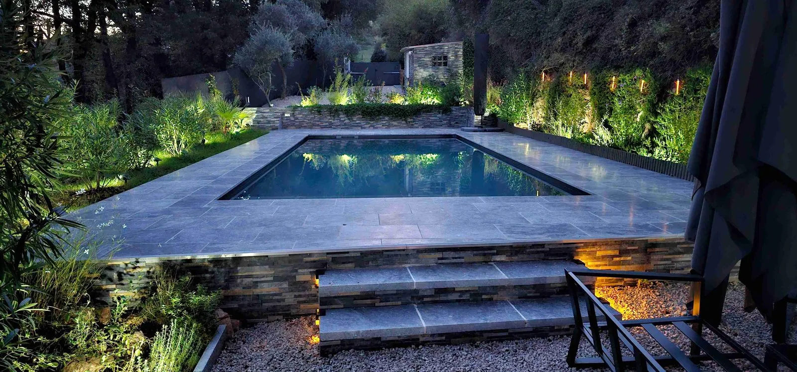 Transformation piscine moderne après rénovation PVC armé, éclairage nocturne et terrasse pierre